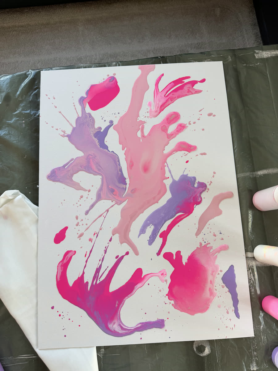 Frisch gegossene Acrylfarben in Rosa und Lila auf der Leinwand